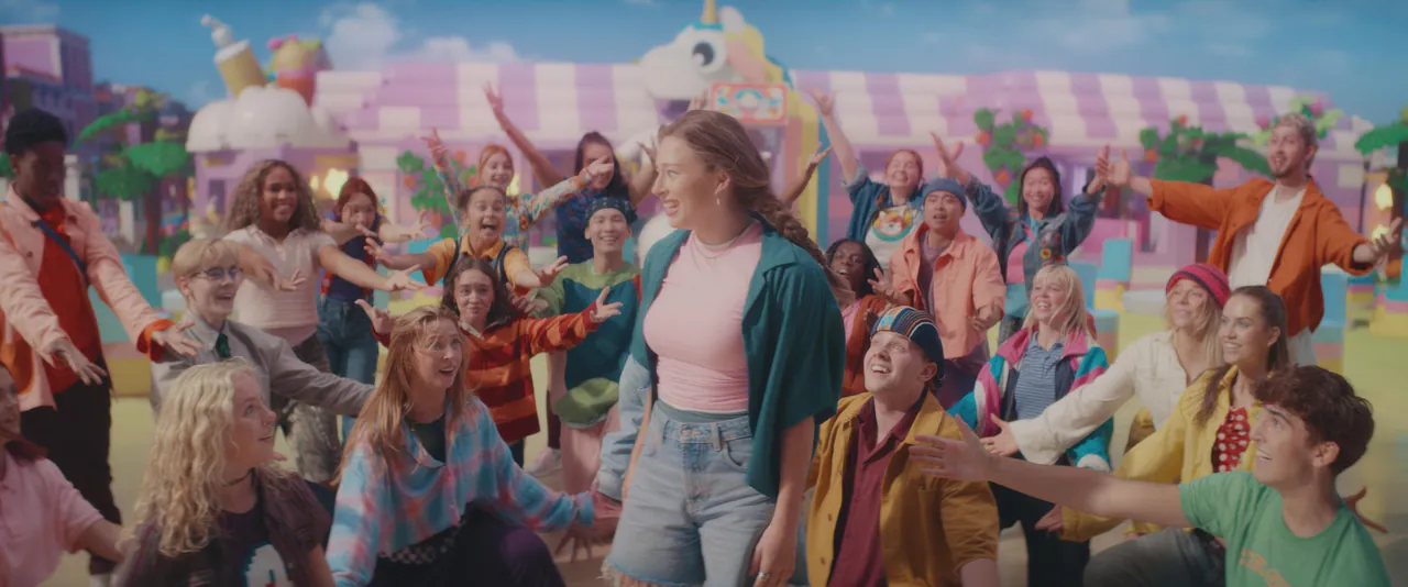 El joven reparto del musical de LEGO Friends baila en una calle colorida de Heartlake City