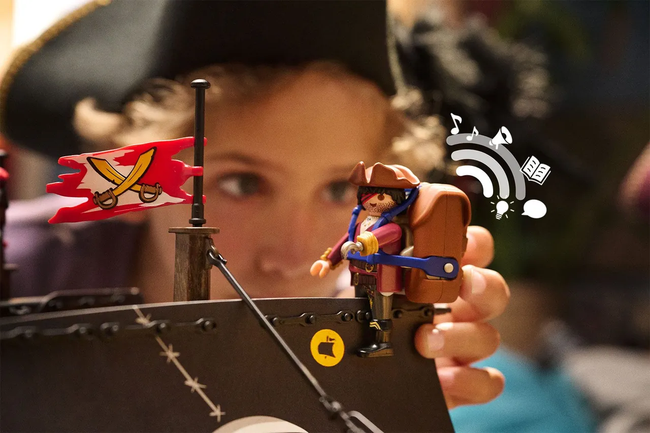 Niño sujetando una figura pirata de Playmobil con la mochila de audio de Playmobil hi!