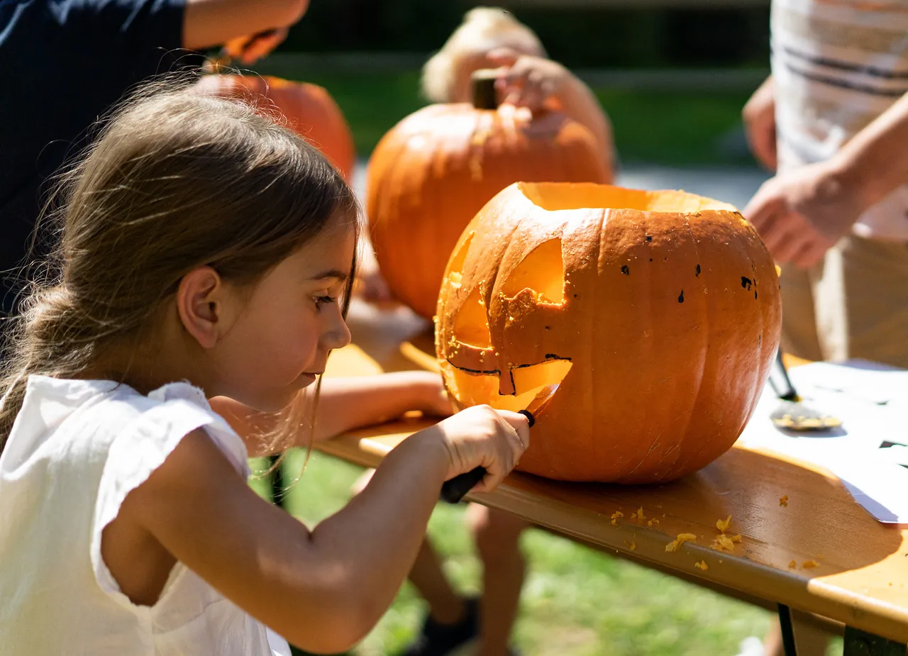 Niña tallando una calabaza en el programa de Halloween de Ravensburger Spieleland